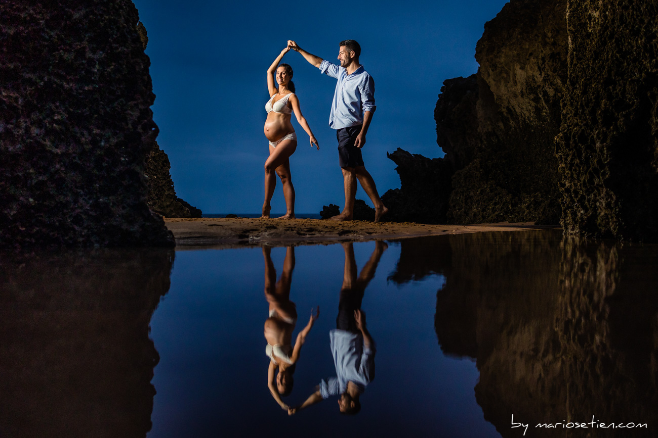 Embarazada con su pareja bailando al atardecer en Liencres