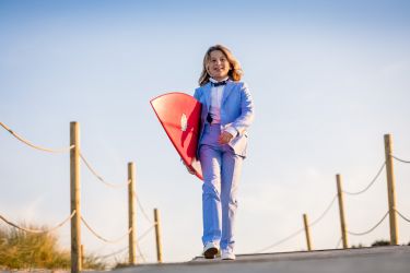 Sesión de fotos de Primera Comunión en San Vicente de la Barquera con una tabla de surf